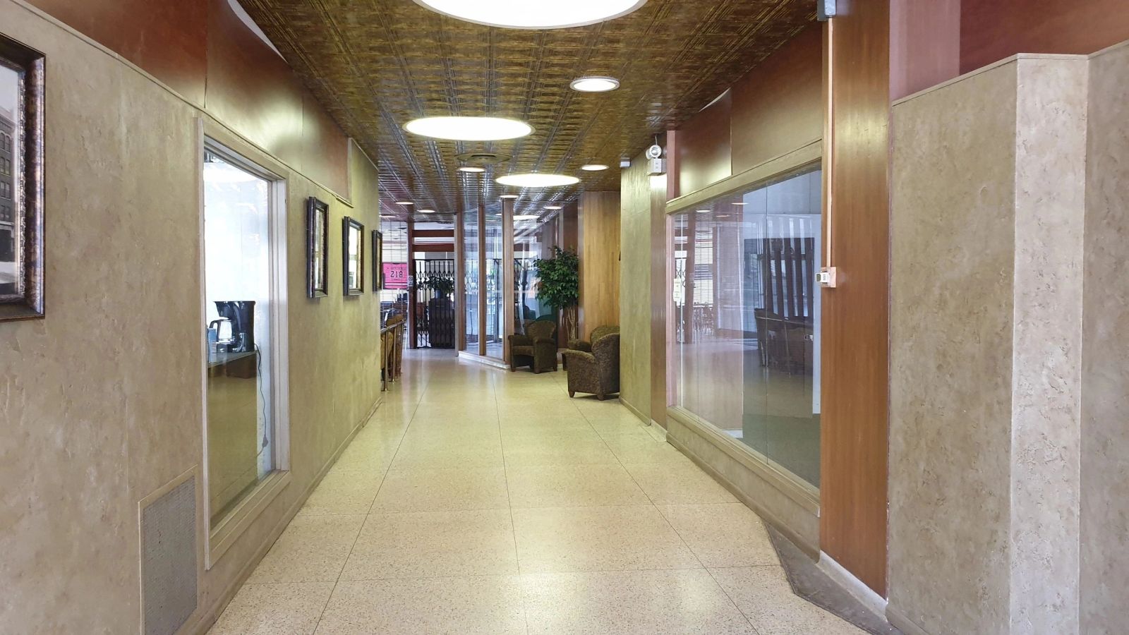 Tenant corridor at 302 Chestnut lined with office entries and a pressed-tin ceiling