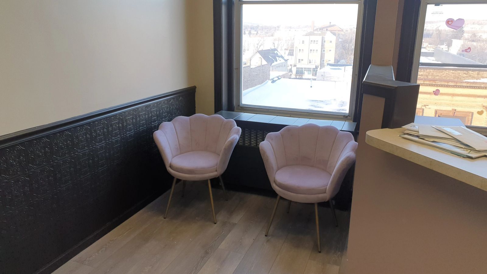 Office seating area at 302 Chestnut with pressed-tin wainscot and windows over downtown Virginia, MN